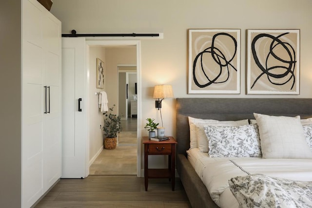 13356 Corte De Chucena, San Diego, CA 92128 - bedroom featuring wood finished floors, a barn door, and baseboards