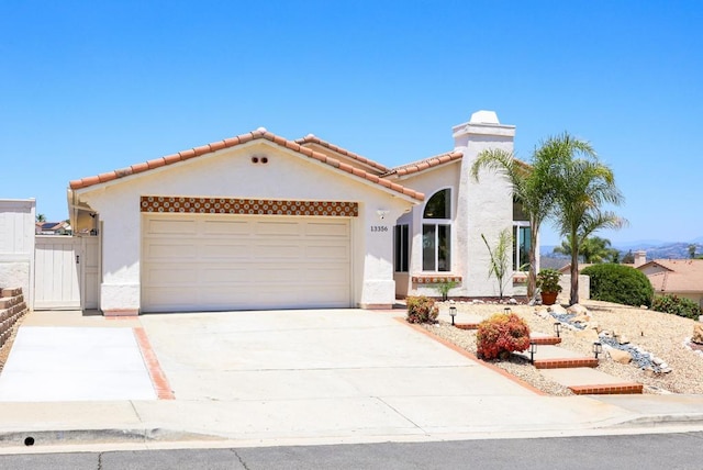 13356 Corte De Chucena, San Diego, CA 92128 - mediterranean / spanish-style home with stucco siding, an attached garage, driveway, and a tiled roof