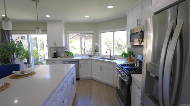 13356 Corte De Chucena, San Diego, CA 92128 - kitchen with appliances with stainless steel finishes, a sink, light wood-style floors, backsplash, and white cabinets