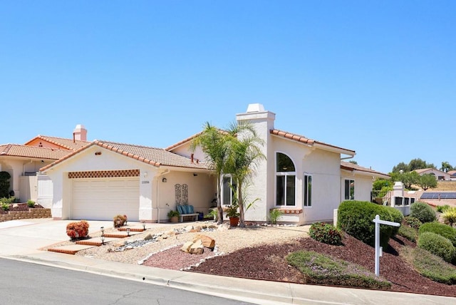 13356 Corte De Chucena, San Diego, CA 92128 - mediterranean / spanish-style house featuring a chimney, a tile roof, a garage, and stucco siding