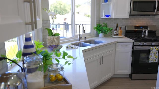 13356 Corte De Chucena, San Diego, CA 92128 - kitchen featuring stainless steel appliances, white cabinetry, light countertops, open shelves, and tasteful backsplash