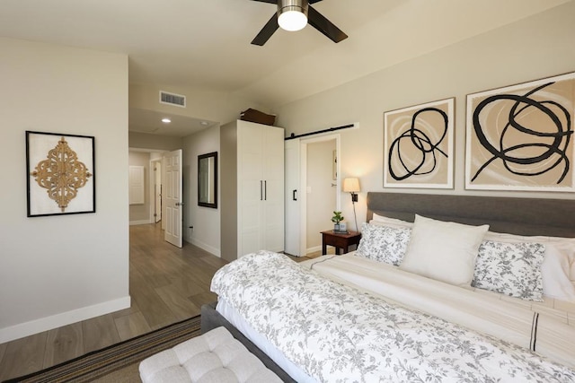 13356 Corte De Chucena, San Diego, CA 92128 - bedroom featuring a barn door, wood finished floors, lofted ceiling, and ceiling fan