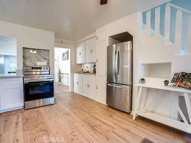 25 W Walnut St, Stockton, CA 95204 - kitchen featuring stainless steel appliances, light wood finished floors, and white cabinetry