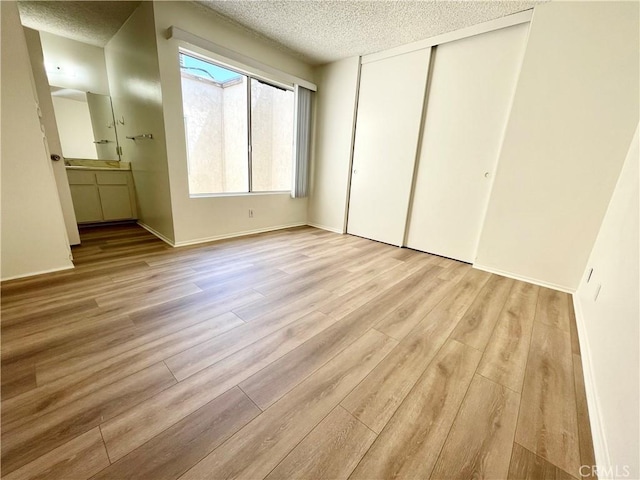 220 N Alhambra Ave Unit B, Monterey Park, CA 91755 - unfurnished bedroom featuring a textured ceiling, wood finished floors, a closet, and baseboards