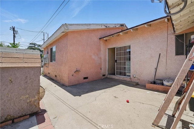 14276 Aztec St, Sylmar, CA 91342 - view of side of home with crawl space, a patio, and stucco siding