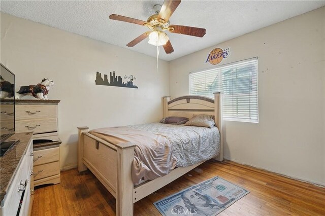 14276 Aztec St, Sylmar, CA 91342 - bedroom featuring wood finished floors, a textured ceiling, and ceiling fan