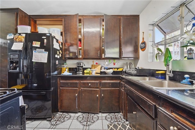14276 Aztec St, Sylmar, CA 91342 - kitchen with black fridge with ice dispenser, dark countertops, a sink, range, and light tile patterned floors