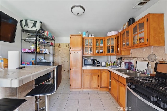 14276 Aztec St, Sylmar, CA 91342 - kitchen featuring stainless steel appliances, tile counters, light tile patterned flooring, and decorative backsplash