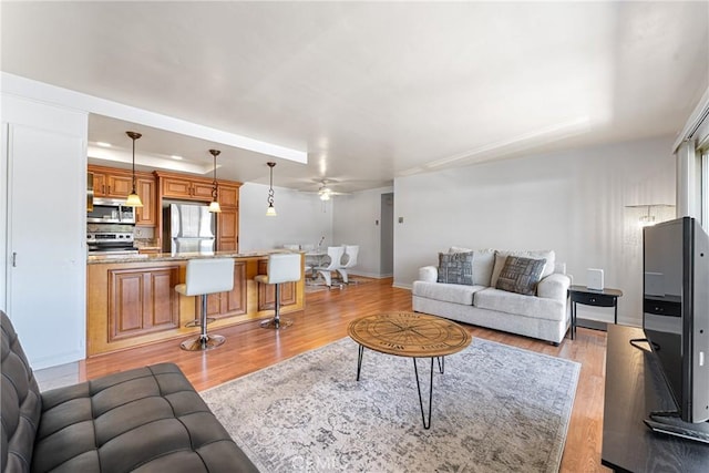 2338 Avenida Sevilla Unit P, Laguna Woods, CA 92637 - living area featuring light wood-style flooring, ceiling fan, and baseboards