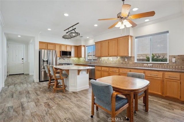 19613 Edmonds Pl, Saugus, CA 91350 - kitchen with appliances with stainless steel finishes, crown molding, decorative backsplash, recessed lighting, and a center island