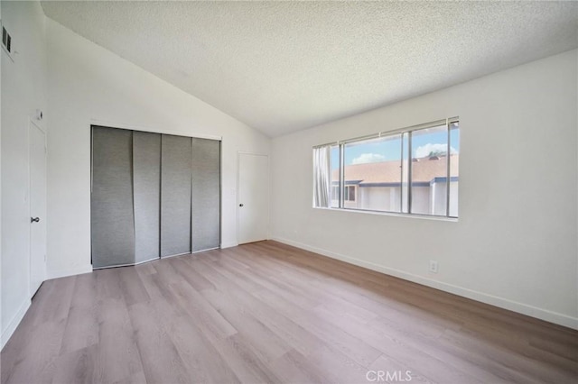 1926 Lucas St Unit 2, San Fernando, CA 91340 - unfurnished bedroom with a textured ceiling, wood finished floors, a closet, vaulted ceiling, and baseboards