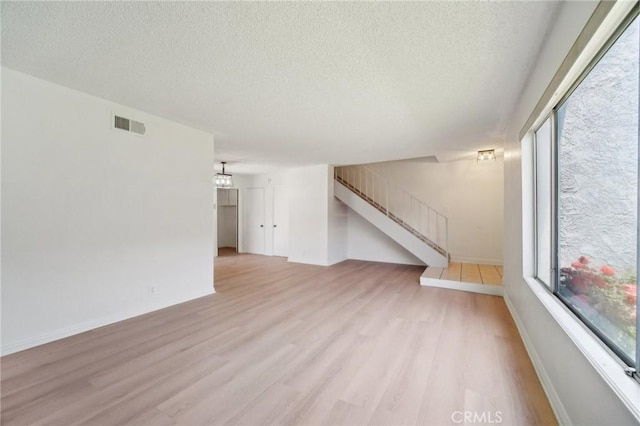 1926 Lucas St Unit 2, San Fernando, CA 91340 - unfurnished living room with wood finished floors, stairs, a textured ceiling, and baseboards