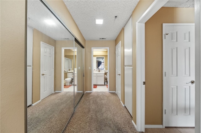 43195 Andrade Ave Unit L, Hemet, CA 92544 - hallway with a textured ceiling, baseboards, and carpet