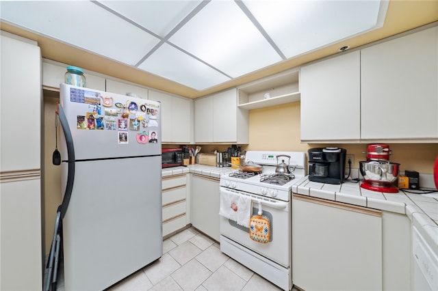 43195 Andrade Ave Unit L, Hemet, CA 92544 - kitchen with white appliances, tile countertops, white cabinetry, and light tile patterned floors