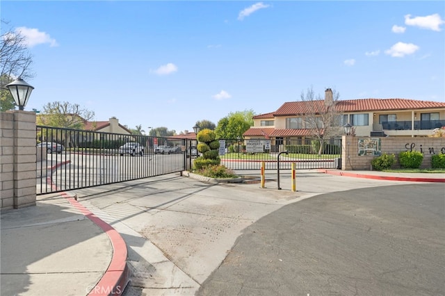 43195 Andrade Ave Unit L, Hemet, CA 92544 - view of asphalt road with a gate, curbs, and street lights