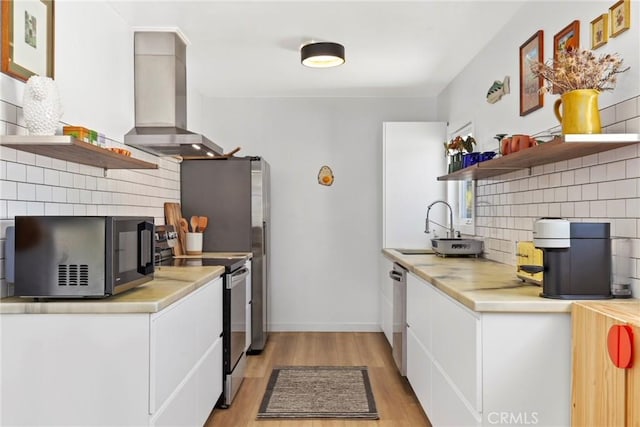 1156 W 26th St, San Pedro, CA 90731 - kitchen featuring appliances with stainless steel finishes, open shelves, wall chimney exhaust hood, decorative backsplash, and light countertops