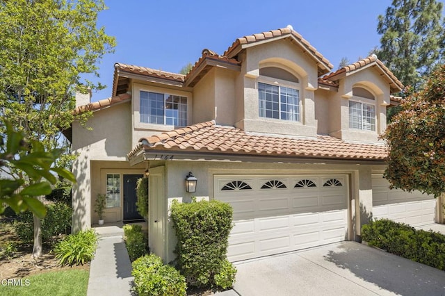 1164 Amberton Ln, Newbury Park, CA 91320 - mediterranean / spanish house featuring a garage, a tile roof, stucco siding, driveway, and a chimney