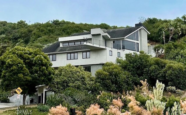 901 Summit Dr, Laguna Beach, CA 92651 - view of side of home with a balcony, a chimney, and stucco siding