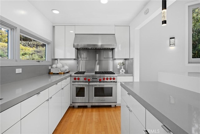 901 Summit Dr, Laguna Beach, CA 92651 - kitchen featuring range with two ovens, wall chimney exhaust hood, white cabinets, modern cabinets, and recessed lighting