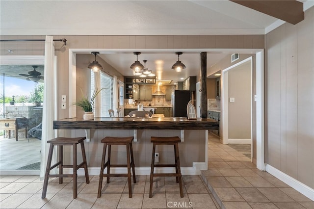 9331 E Mesa Ave, Clovis, CA 93619 - kitchen featuring freestanding refrigerator, a peninsula, dark countertops, and a kitchen breakfast bar