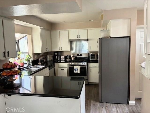 2249 Montrose Ave Unit 7, Montrose, CA 91020 - kitchen featuring stainless steel appliances, dark countertops, a peninsula, and wood finished floors