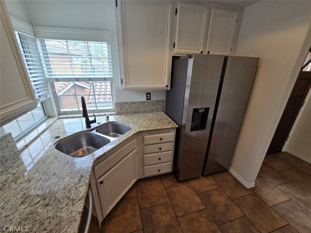 23 Gauguin Cir, Aliso Viejo, CA 92656 - kitchen featuring stainless steel refrigerator with ice dispenser, a sink, white cabinets, and light stone countertops
