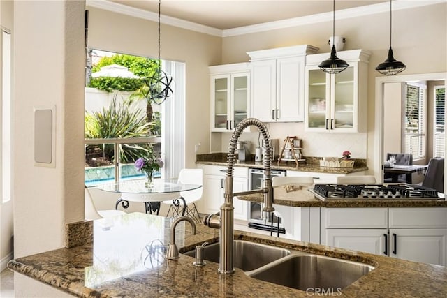 31291 Via Fajita, San Juan Capistrano, CA 92675 - kitchen featuring dark stone countertops, decorative light fixtures, stainless steel gas stovetop, white cabinets, and ornamental molding
