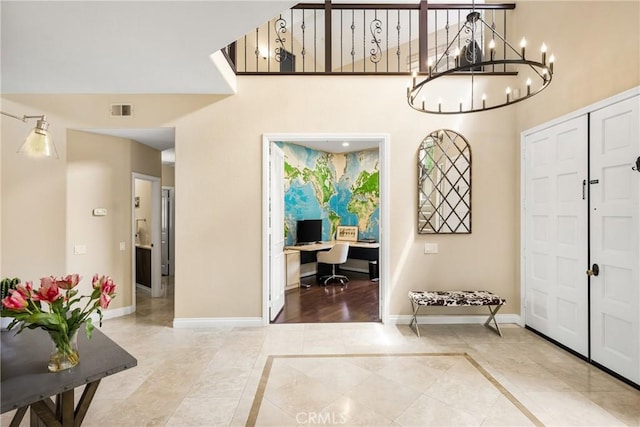 31291 Via Fajita, San Juan Capistrano, CA 92675 - entryway with baseboards, a towering ceiling, a chandelier, light tile patterned floors, and inlaid floor details