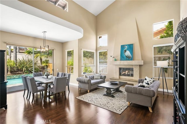 31291 Via Fajita, San Juan Capistrano, CA 92675 - living area featuring a fireplace, a chandelier, wood finished floors, baseboards, and a towering ceiling