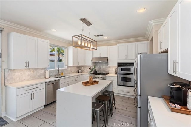 26273 Palm Tree Ln, Murrieta, CA 92563 - kitchen featuring stainless steel appliances, under cabinet range hood, a breakfast bar, a sink, and a center island