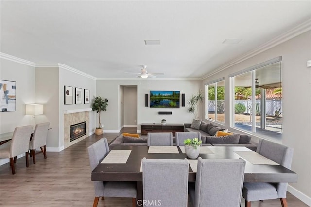 26273 Palm Tree Ln, Murrieta, CA 92563 - dining room with wood finished floors, ornamental molding, baseboards, a tile fireplace, and a ceiling fan