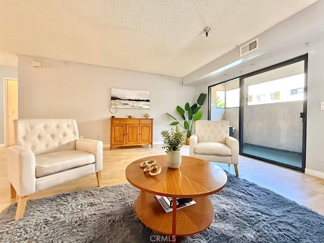 4142 E Mendez St Unit 132, Long Beach, CA 90815 - living area with light wood-type flooring, a textured ceiling, and baseboards