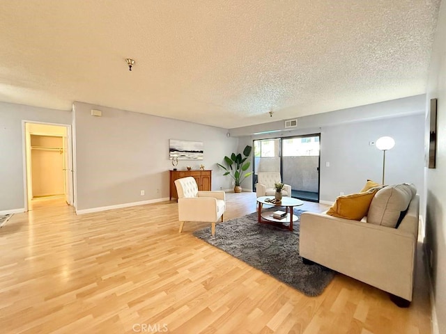 4142 E Mendez St Unit 132, Long Beach, CA 90815 - living room with a textured ceiling, light wood-style flooring, and baseboards