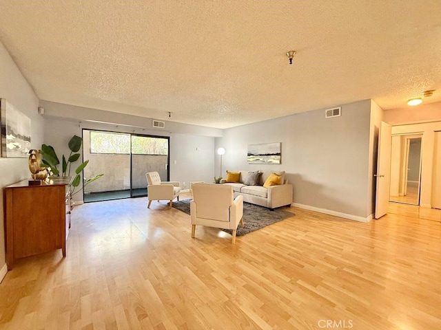 4142 E Mendez St Unit 132, Long Beach, CA 90815 - living area with a textured ceiling, light wood-style floors, and baseboards