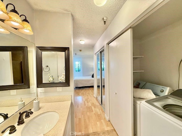 4142 E Mendez St Unit 132, Long Beach, CA 90815 - bathroom with a textured ceiling, wood finished floors, washer and dryer, vanity, and ensuite bathroom