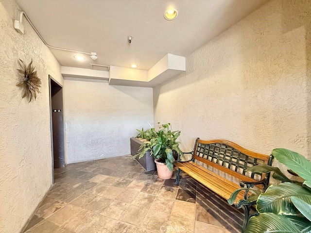 4142 E Mendez St Unit 132, Long Beach, CA 90815 - hallway with a textured wall, stone finish floors, and recessed lighting