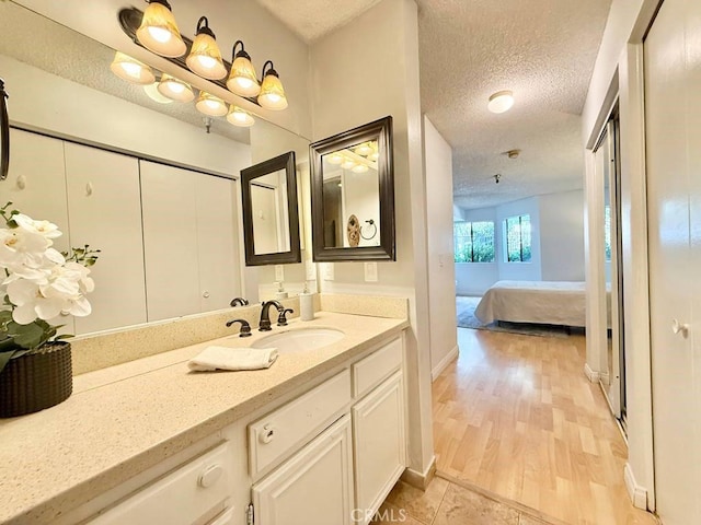 4142 E Mendez St Unit 132, Long Beach, CA 90815 - bathroom featuring a textured ceiling, vanity, ensuite bathroom, and wood finished floors