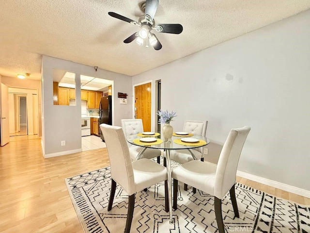 4142 E Mendez St Unit 132, Long Beach, CA 90815 - dining room with light wood-style floors, a textured ceiling, a ceiling fan, and baseboards
