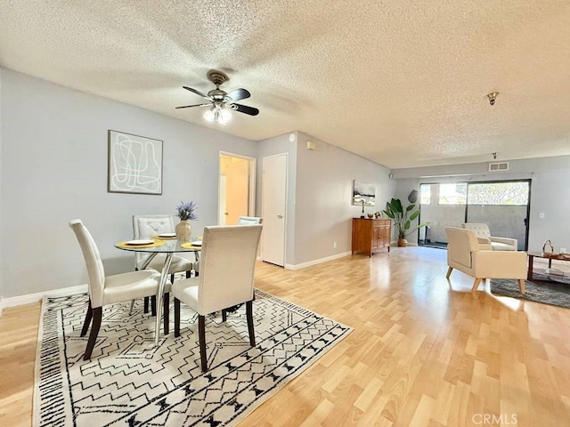 4142 E Mendez St Unit 132, Long Beach, CA 90815 - dining room with light wood-style flooring, a textured ceiling, ceiling fan, and baseboards