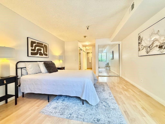 4142 E Mendez St Unit 132, Long Beach, CA 90815 - bedroom with light wood finished floors, a textured ceiling, and baseboards