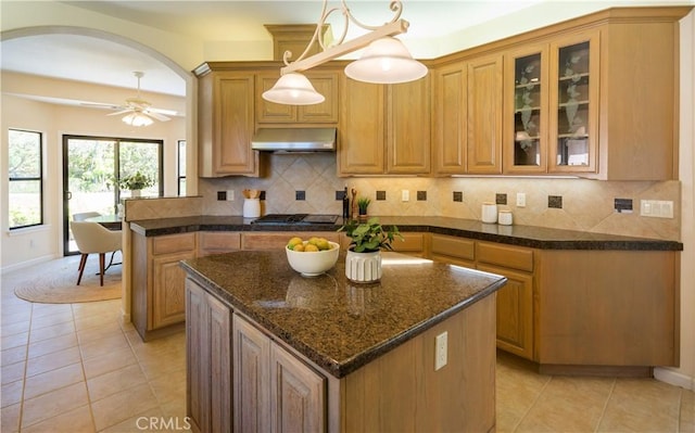 570 Jenny Pl, Arroyo Grande, CA 93420 - kitchen with ventilation hood, arched walkways, light tile patterned floors, backsplash, and glass insert cabinets
