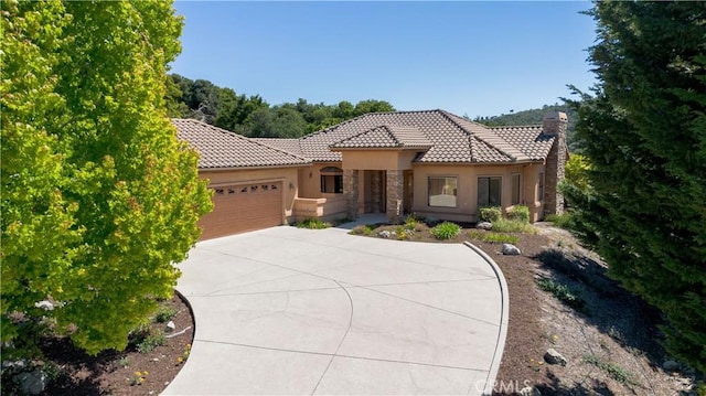 570 Jenny Pl, Arroyo Grande, CA 93420 - mediterranean / spanish-style home featuring a garage, stucco siding, a tiled roof, concrete driveway, and stone siding