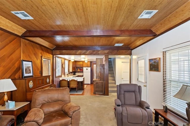 681 Chipmunk Ln, Big Bear Lake, CA 92315 - living area featuring wood ceiling with exposed beams, stairway, wooden walls, and light colored carpet
