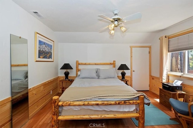 681 Chipmunk Ln, Big Bear Lake, CA 92315 - bedroom featuring wood finished floors, a wainscoted wall, wooden walls, and a ceiling fan