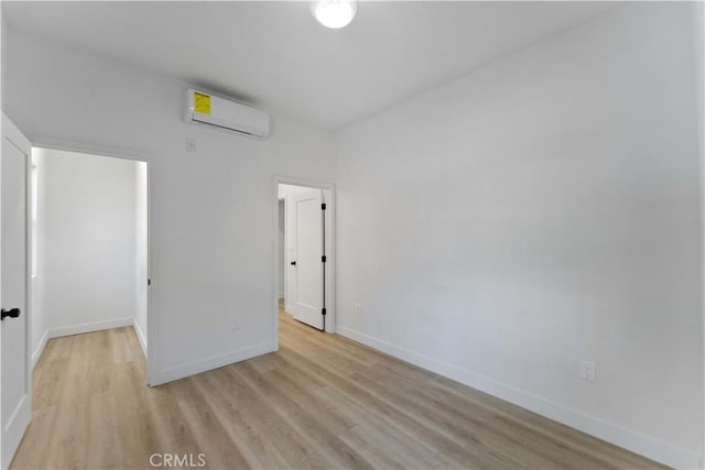 752 E 17th St, Los Angeles, CA 90021 - unfurnished bedroom featuring a wall unit AC, light wood-type flooring, and baseboards