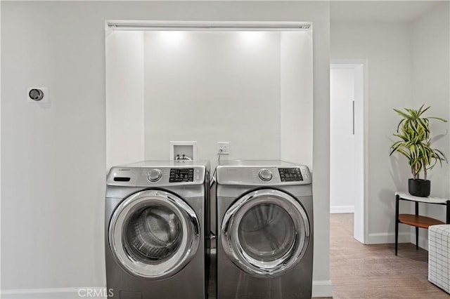 5834 Satsuma Ave, North Hollywood, CA 91601 - washroom featuring separate washer and dryer, wood finished floors, and baseboards
