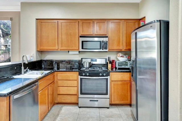 4300 Newton Ave Unit 110, San Diego, CA 92113 - kitchen with stainless steel appliances, a sink, dark stone counters, light tile patterned floors, and a peninsula