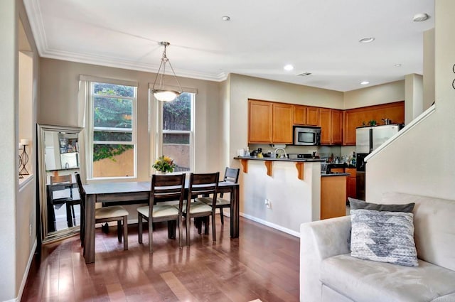 4300 Newton Ave Unit 110, San Diego, CA 92113 - kitchen with stainless steel appliances, dark countertops, brown cabinets, a peninsula, and dark wood-style floors