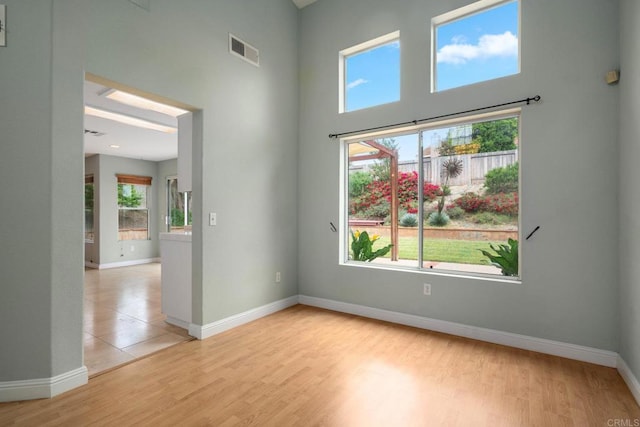 513 Shadow Tree Dr, Oceanside, CA 92058 - spare room with a high ceiling, baseboards, and light wood-style floors