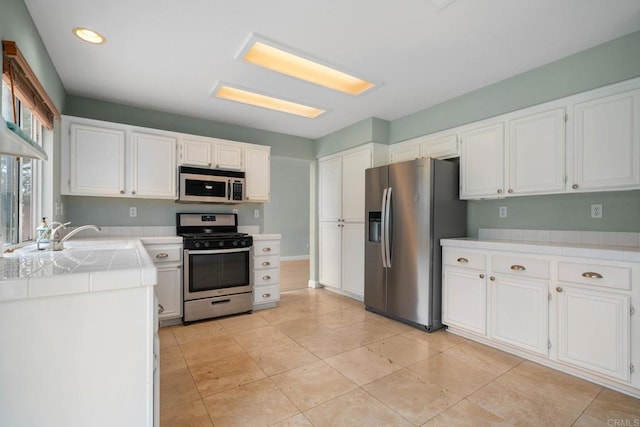 513 Shadow Tree Dr, Oceanside, CA 92058 - kitchen featuring appliances with stainless steel finishes, a sink, tile countertops, white cabinetry, and recessed lighting